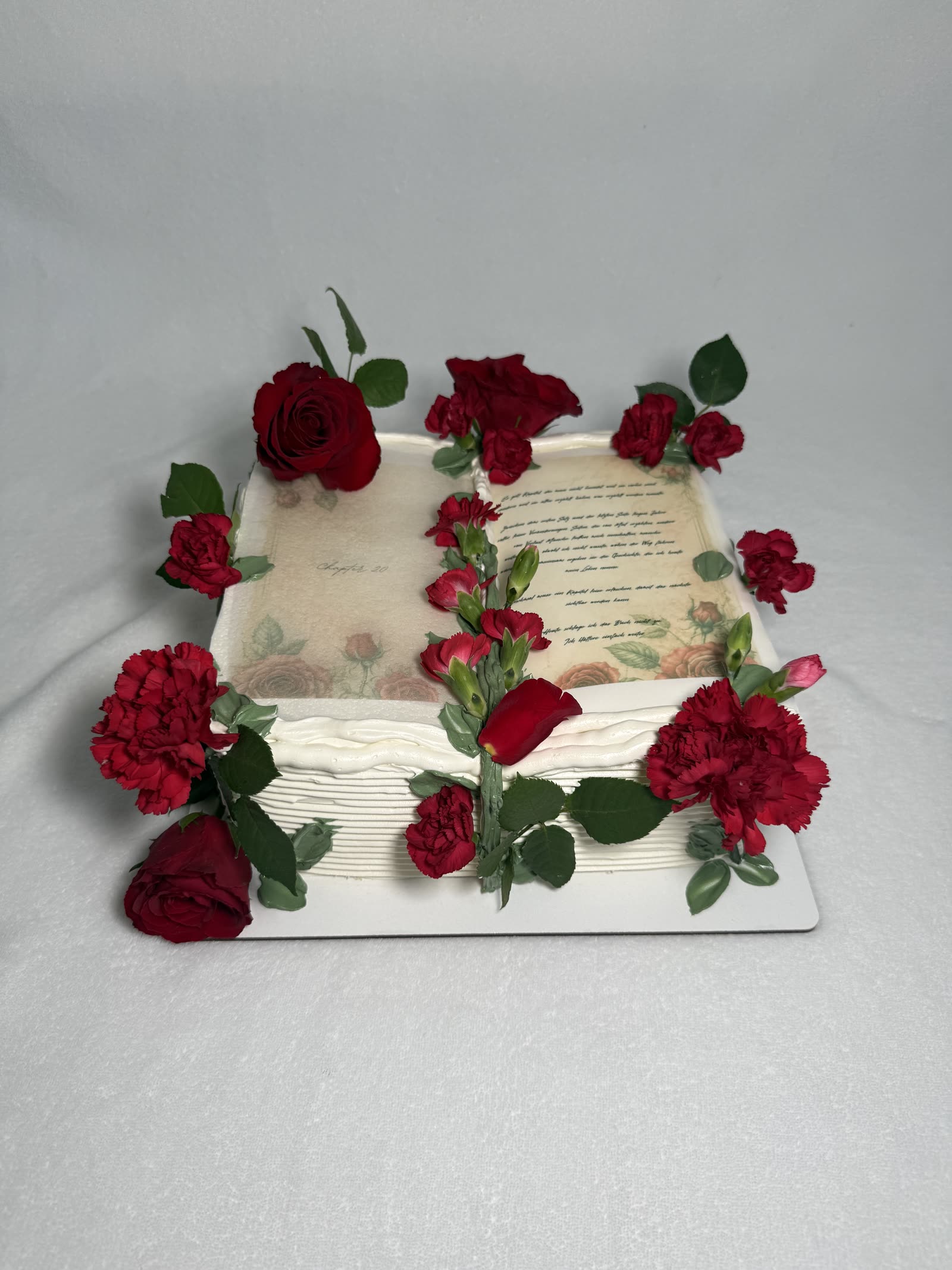 Buchtorte mit roten Rosen